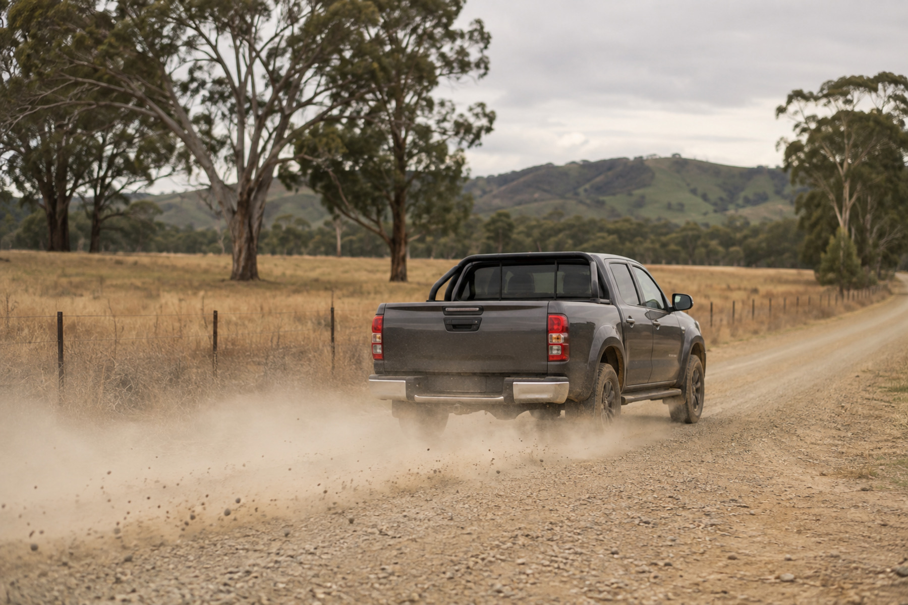 Ute on an unsealed Gippsland road with dust and loose gravel thrown up behind it